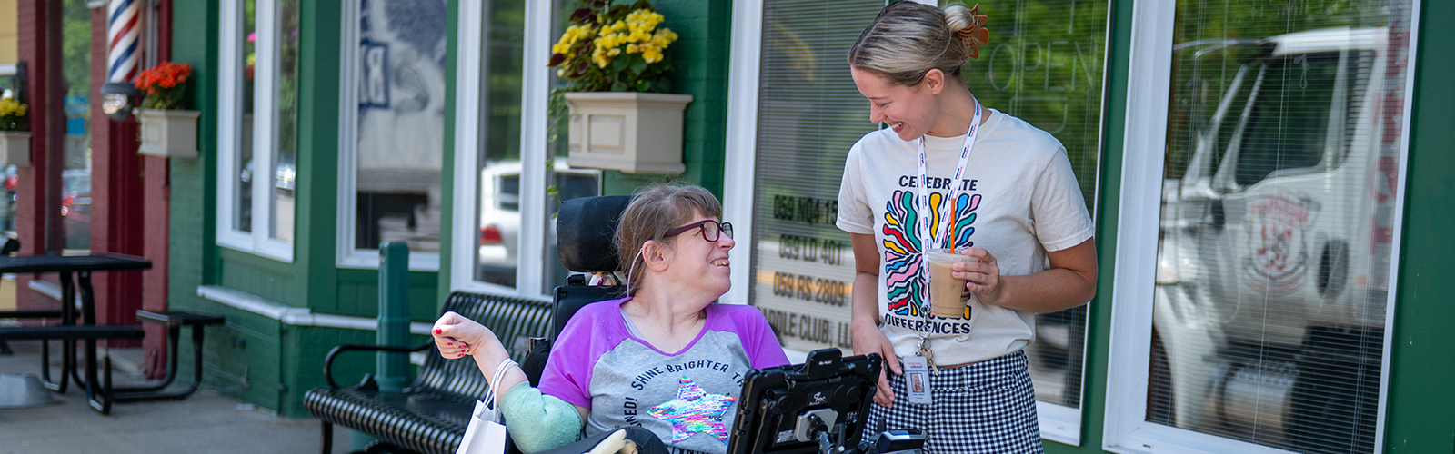 Two women communicating outside a coffee shop